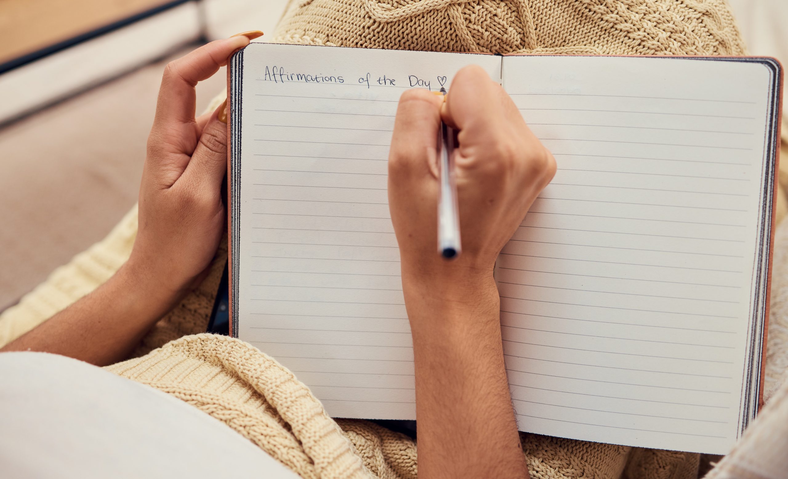 Close-up of a woman journaling with positive affirmations