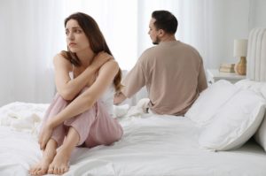 Woman looking thoughtful and worried about intimacy, representing the traits of a narcissistic man in bed.