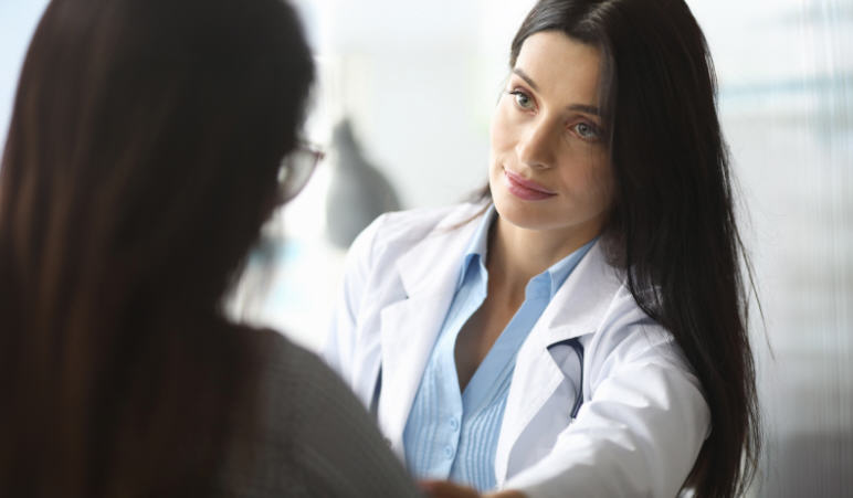 Female patient speaking with a healthcare provider during a calm medical consultation about intimate symptoms in a safe and respectful environment