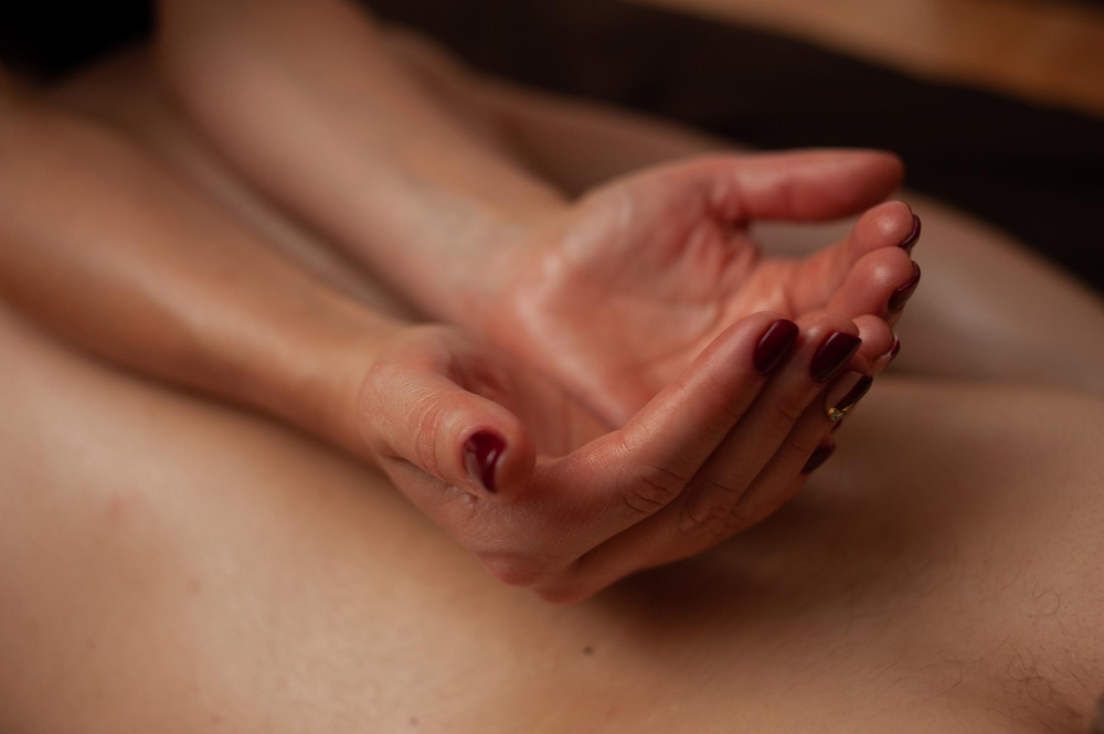 Soft-focus image of massage oil being warmed between palms, symbolizing the gradual buildup of intimacy and the unhurried flow of sensual massage.